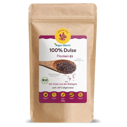 Bio Dulse Flocken 50g von Algenmarkt – rote Algenflocken auf Holzlöffel vor Kraftpapierbeutel