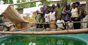 Familiäre Spirulina-Farm in Togo mit Gruppe am Kulturbecken